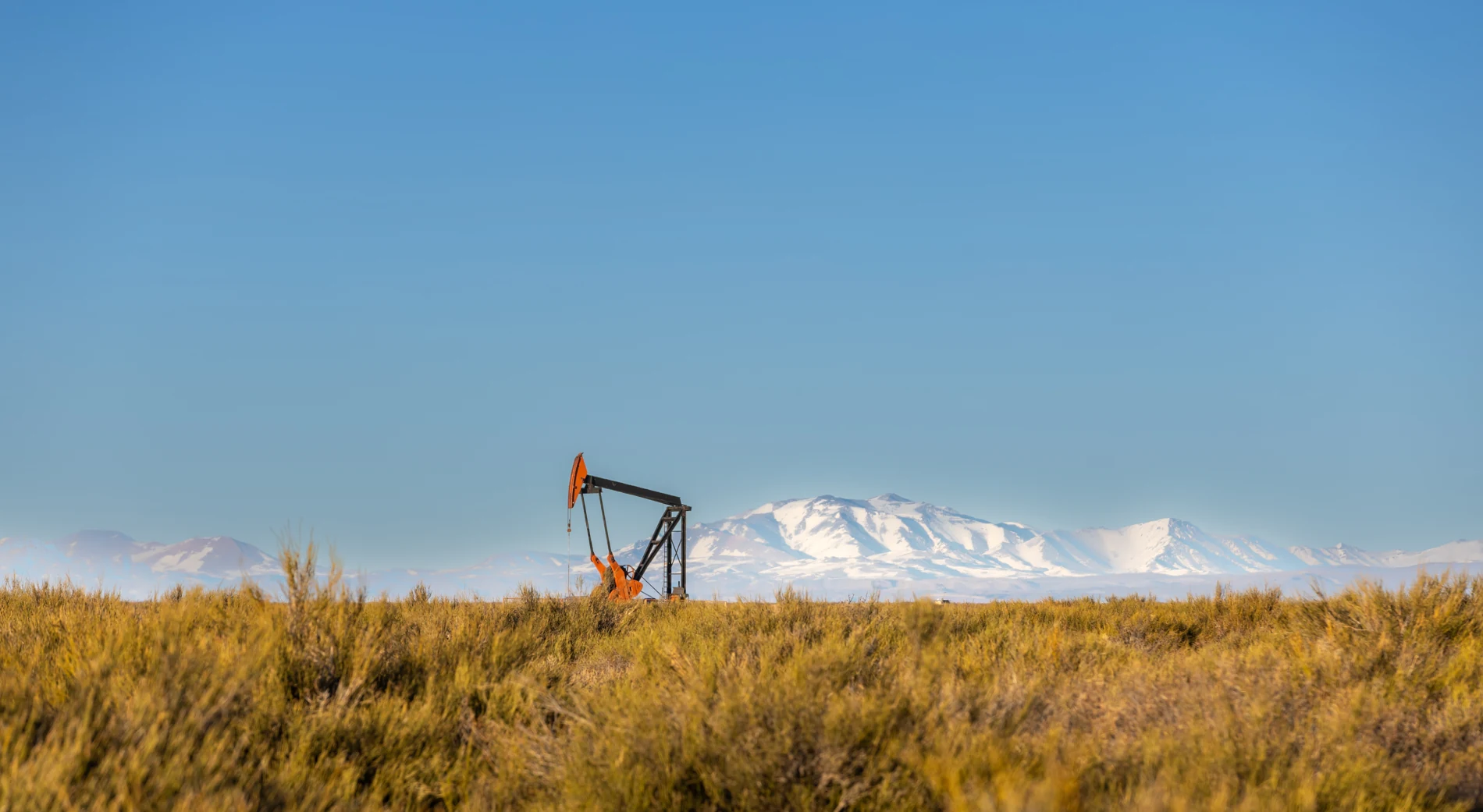 Equipo de extracción de petróleo con las montañas de fondo